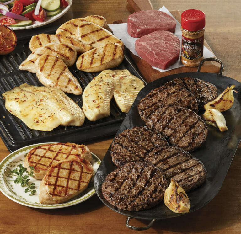 Variety of grilled meats including burgers, chicken breasts, pork chops, fish filets, and steak with bottled seasoning.