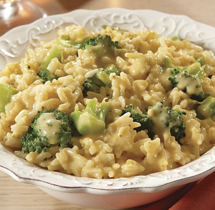 Broccoli, rice and cheese casserole in a white bowl with decorative rim.